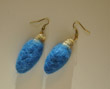 Red earings shaped like Christmas tree light bulbs